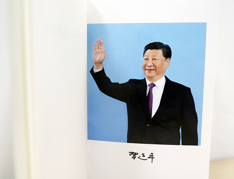 图为《习近平谈治国理政》第二卷扉页后习近平总书记挥手照片,下有总书记个人签名。